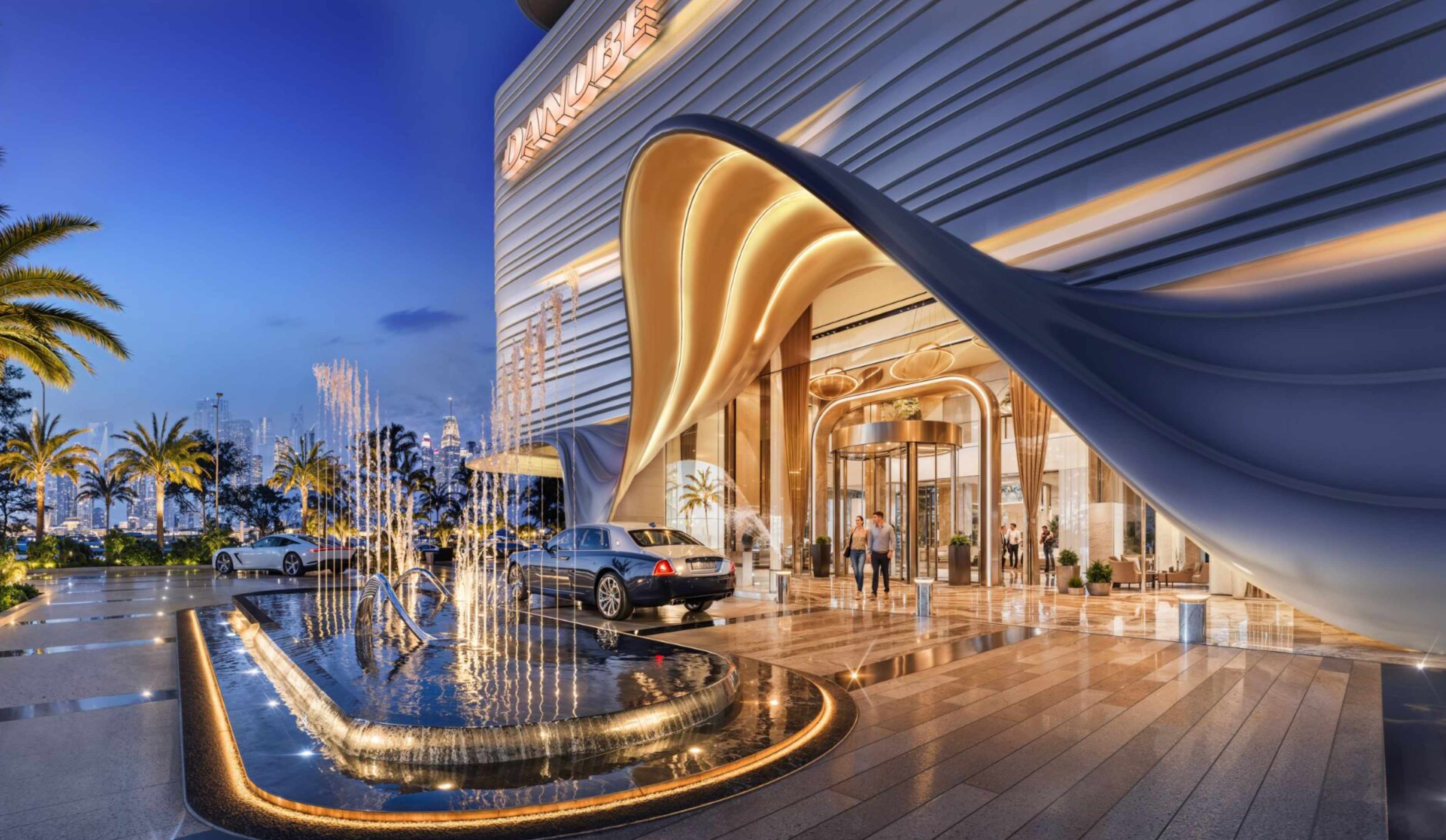 Luxury entrance lobby with water features and premium cars